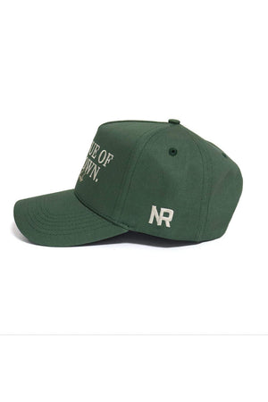 The ALOYO Hat from No Rivals’ No Rivals Collection is a green cotton baseball cap with white "NR" embroidery on the side, partial white front text, and an adjustable snapback for a comfortable, one-size fit. Shown left side view on a white background.